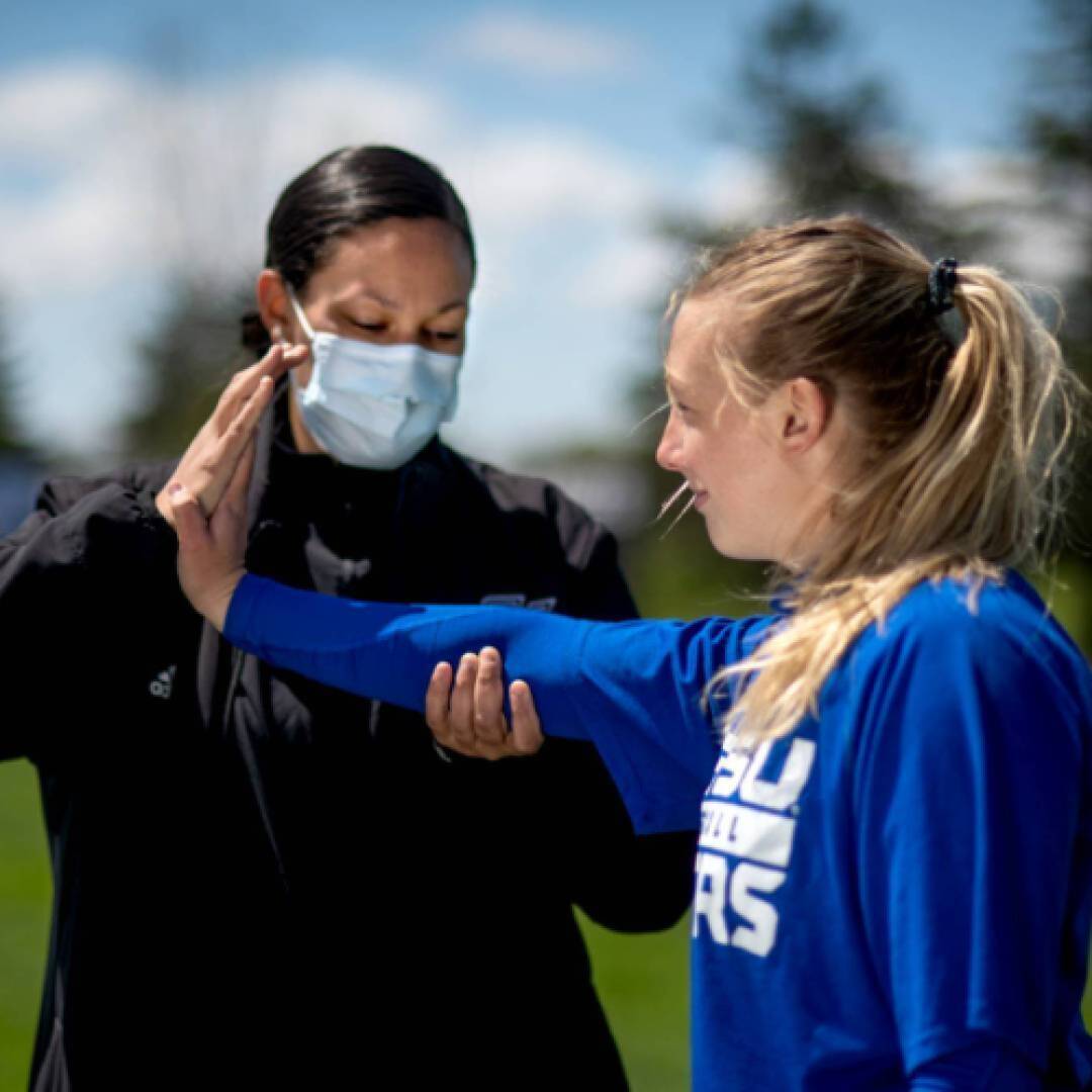 Athletic trainer testing an athlete's wrist motion
